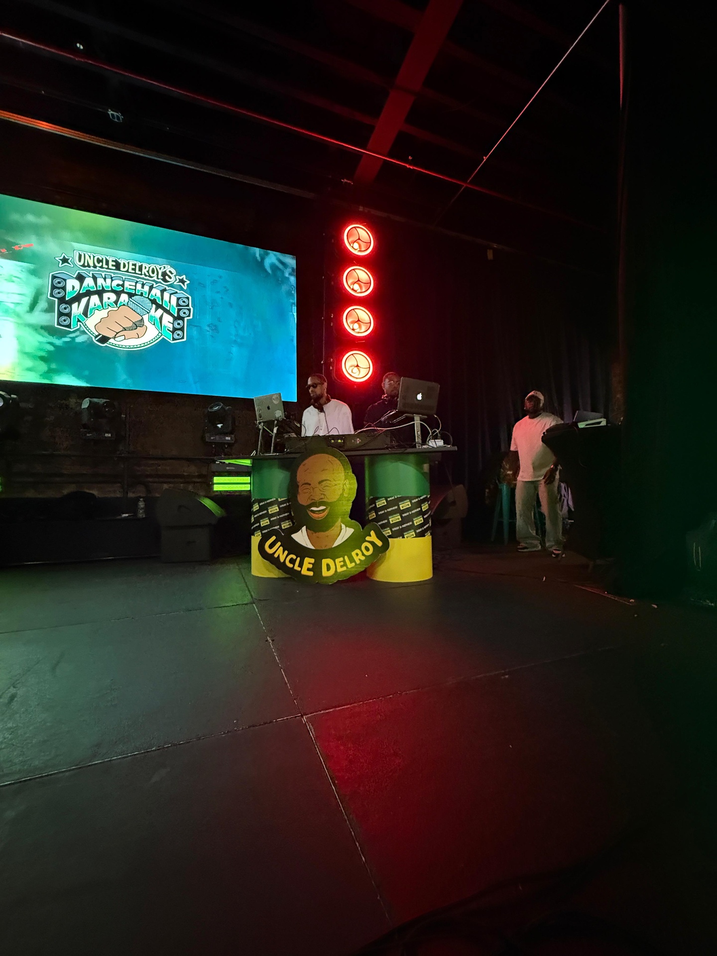 Uncle Delroy DJ booth with branded façade beneath the Dancehall Karaoke LED screen