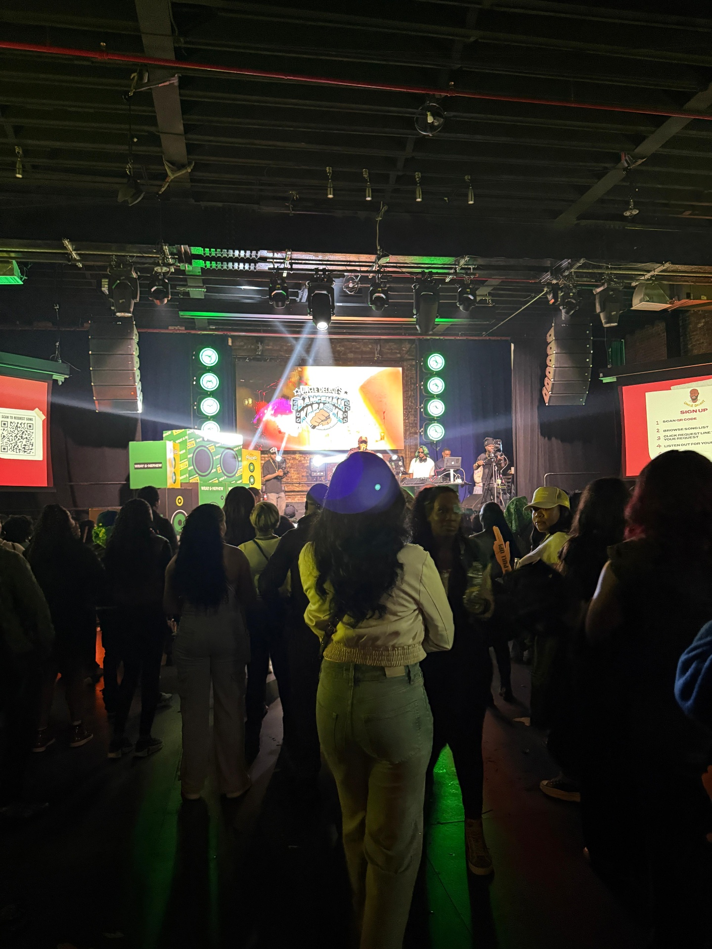 Crowd watching the Uncle Delroy's Dancehall Karaoke stage with branded scenic and DJ booth