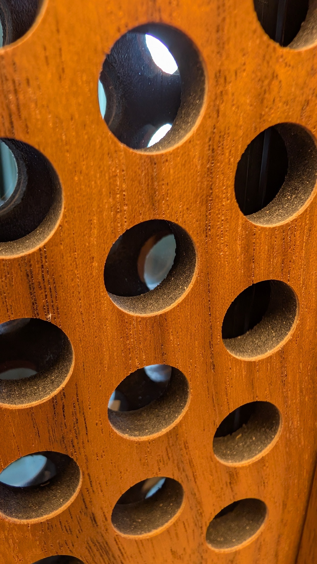 Macro detail of CNC-bored walnut panel revealing material craftsmanship