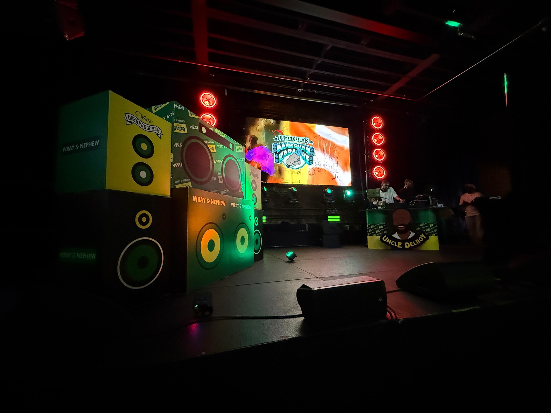 Wray and Nephew Uncle Delroy's Dancehall Karaoke main stage with branded scenic speaker stacks, DJ booth, and LED screen