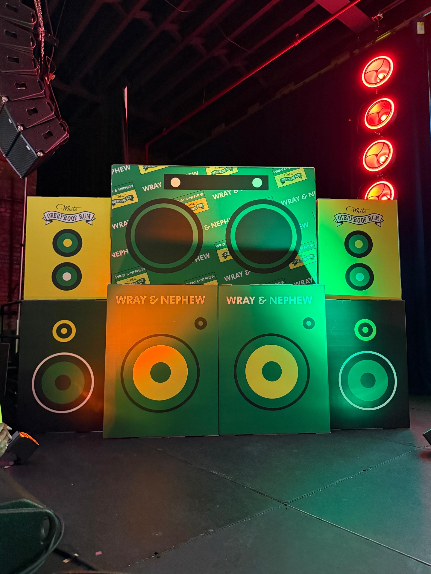 Stacked Wray and Nephew branded scenic speaker panels in green, yellow, and orange